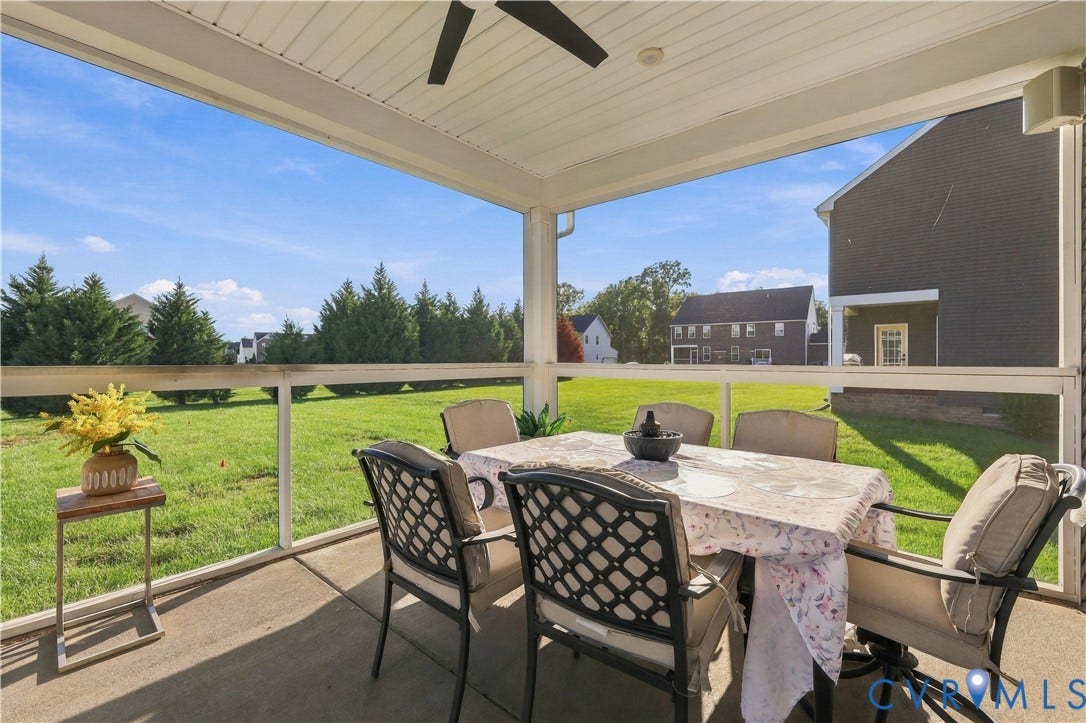 Screened porch with concrete flooring and a ceiling fan