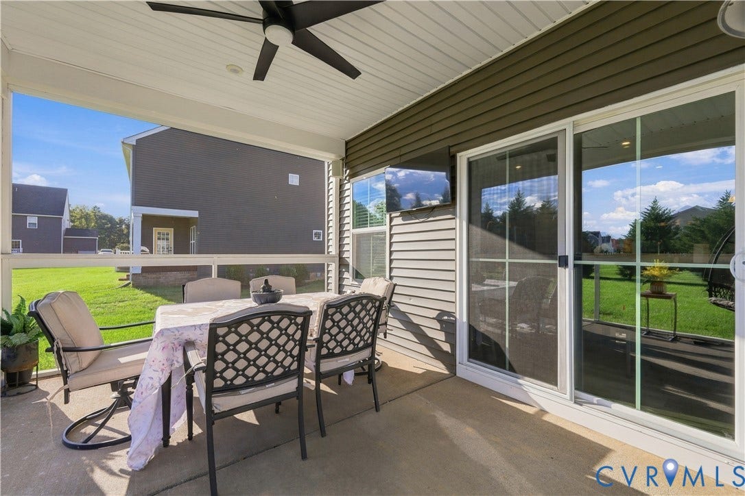 Screened porch with concrete flooring, overhead ceiling fan, and sliding glass door access