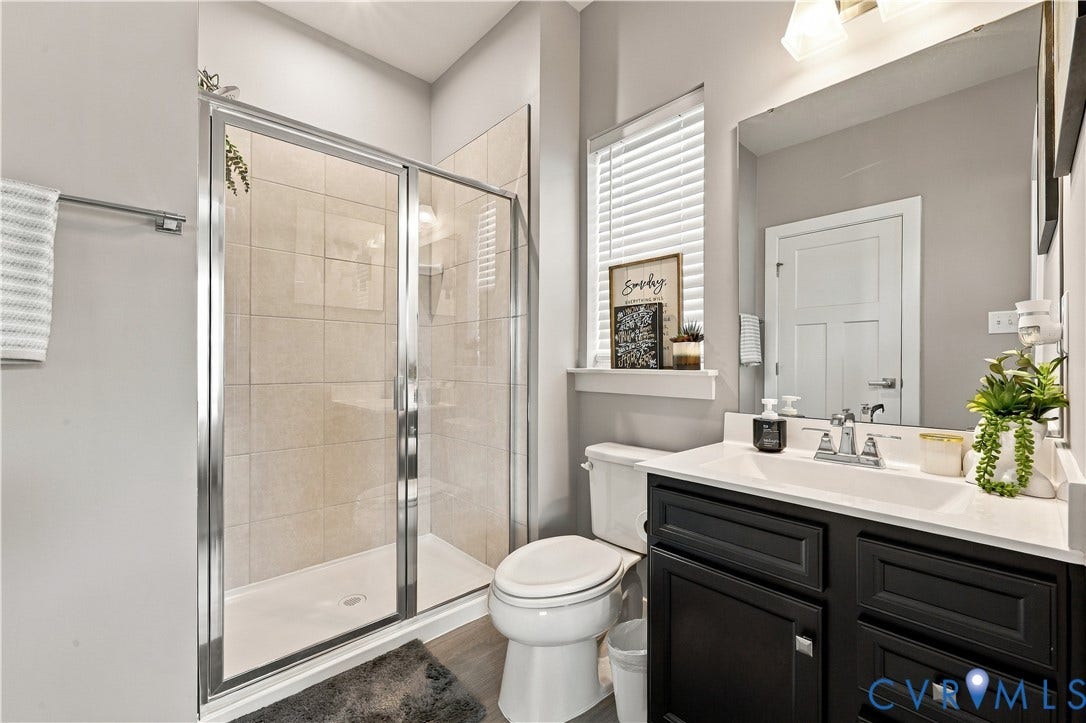 Walk-in shower with clear glass enclosure and tiled walls