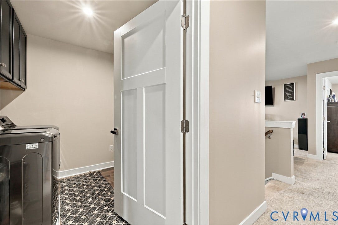 Built-in dark cabinetry with shelving, recessed lighting, and a white paneled door