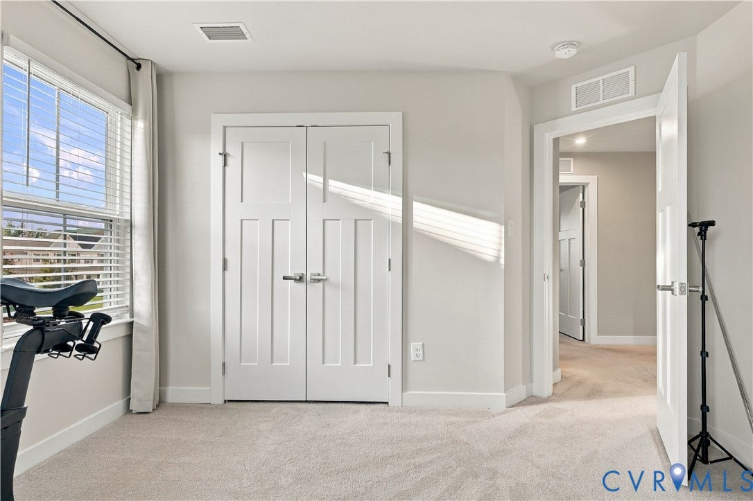 Light-colored wall paint, white trim, and light carpeting create a neutral interior
