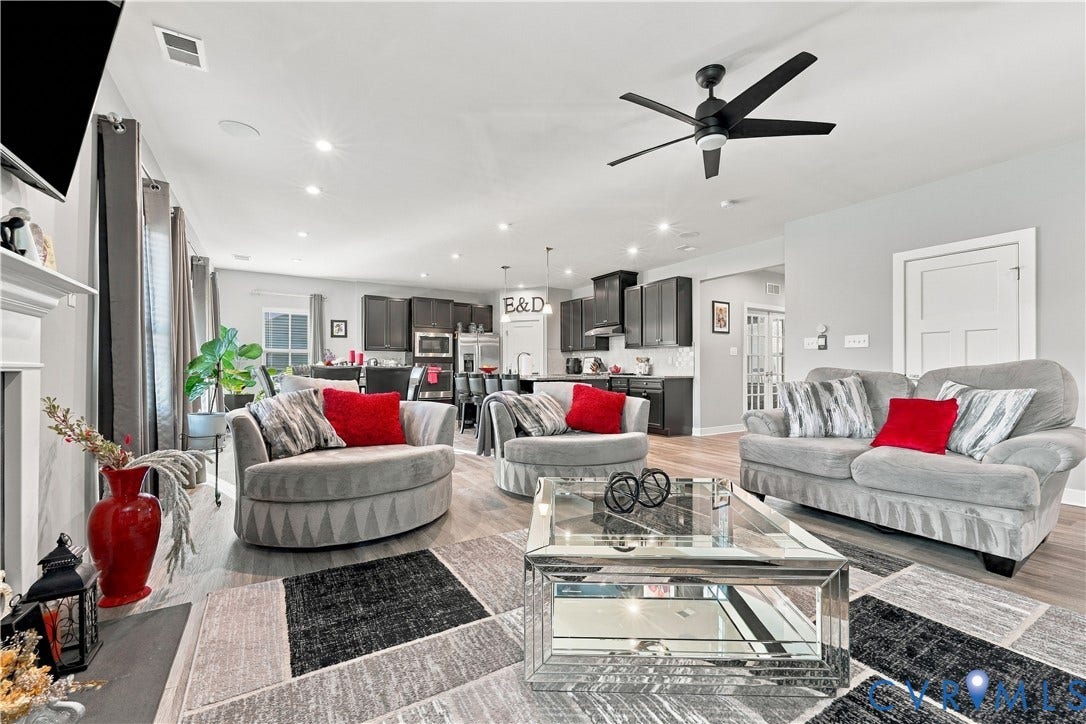 Open-concept living space featuring wood-finish flooring, recessed lighting, and a prominent ceiling fan