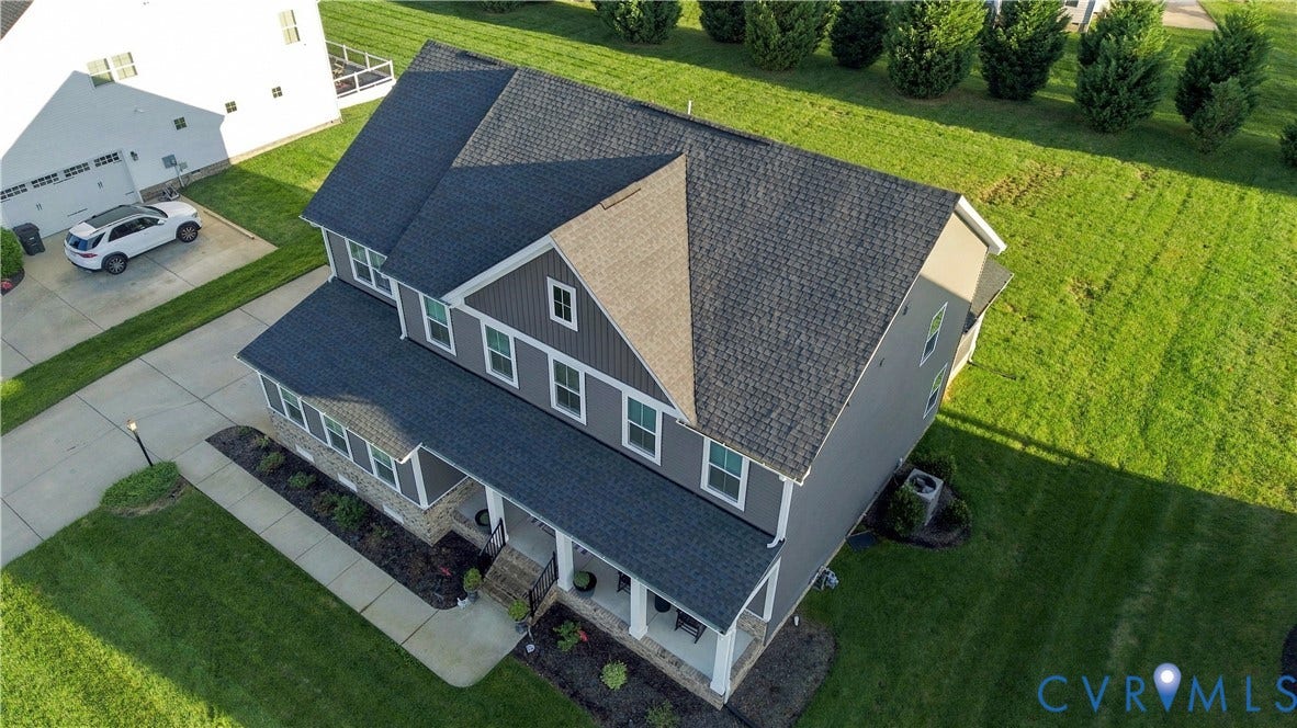 Two-story residence with a multi-gabled roofline, covered front porch, and a concrete driveway