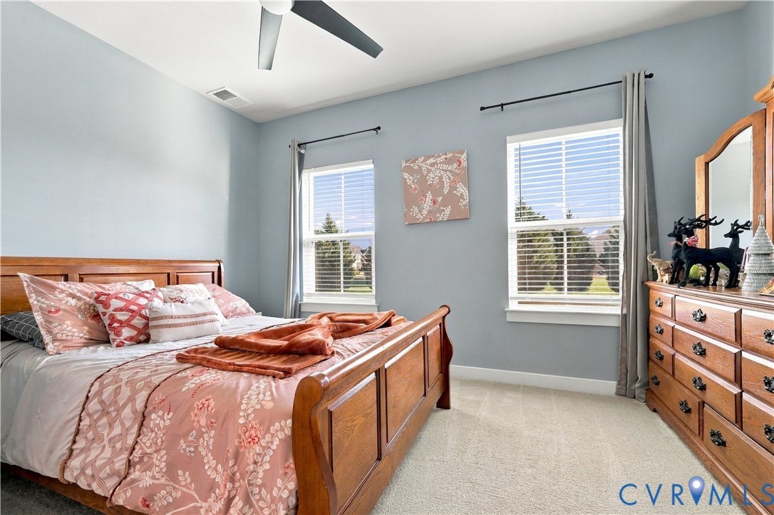 Recessed lighting, ceiling fan, two windows with blinds, and light-toned carpeting