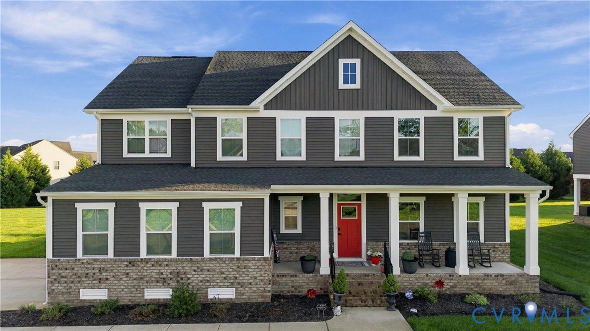 Two-story residence featuring a dark gray siding exterior, contrasting white trim, and a prominent red front door