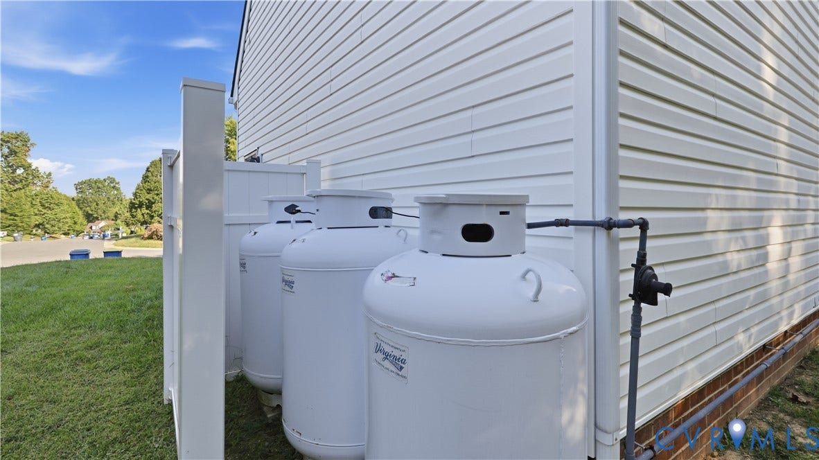 Propane tanks connected to white vinyl siding