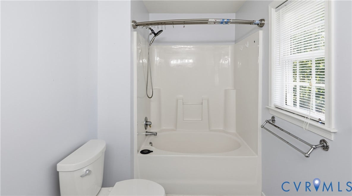 White tub and shower combination with chrome fixtures