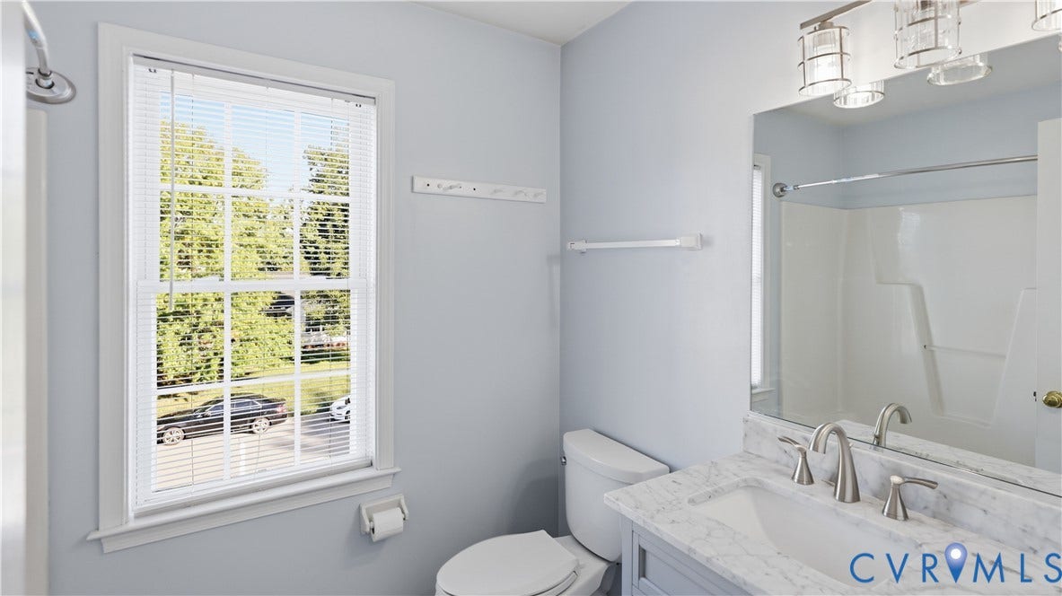 Vanity with marble-finish countertop, single basin sink, and brushed nickel faucet