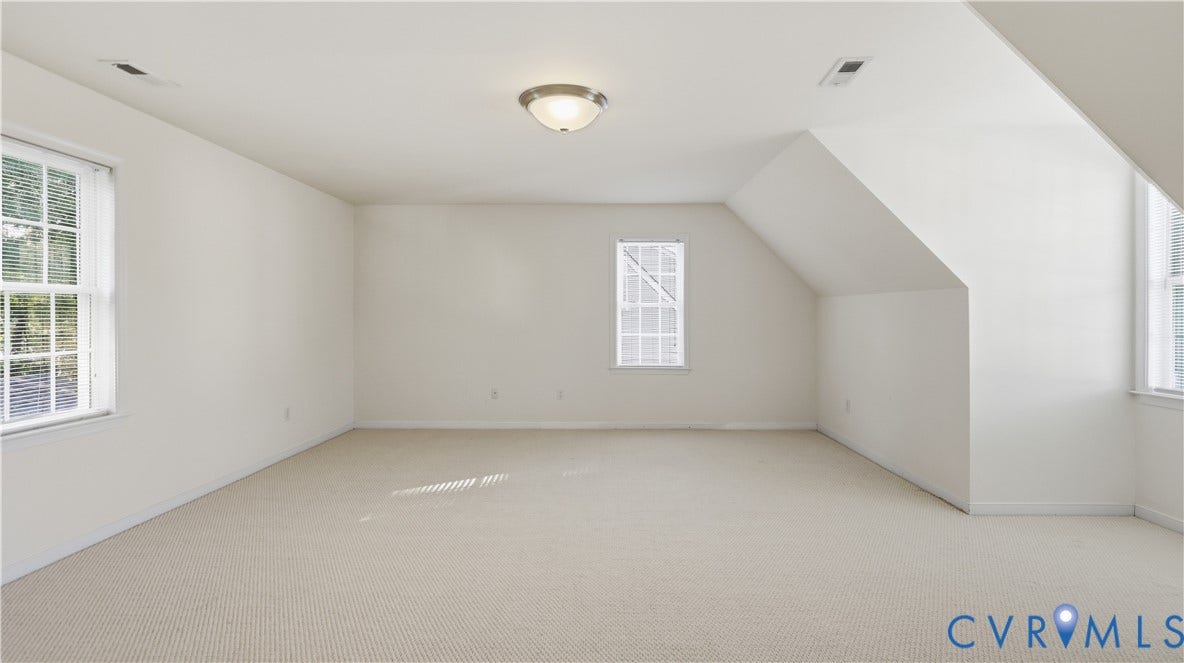 Wall-to-wall carpeting, multiple windows, and a semi-flush mount ceiling light fixture