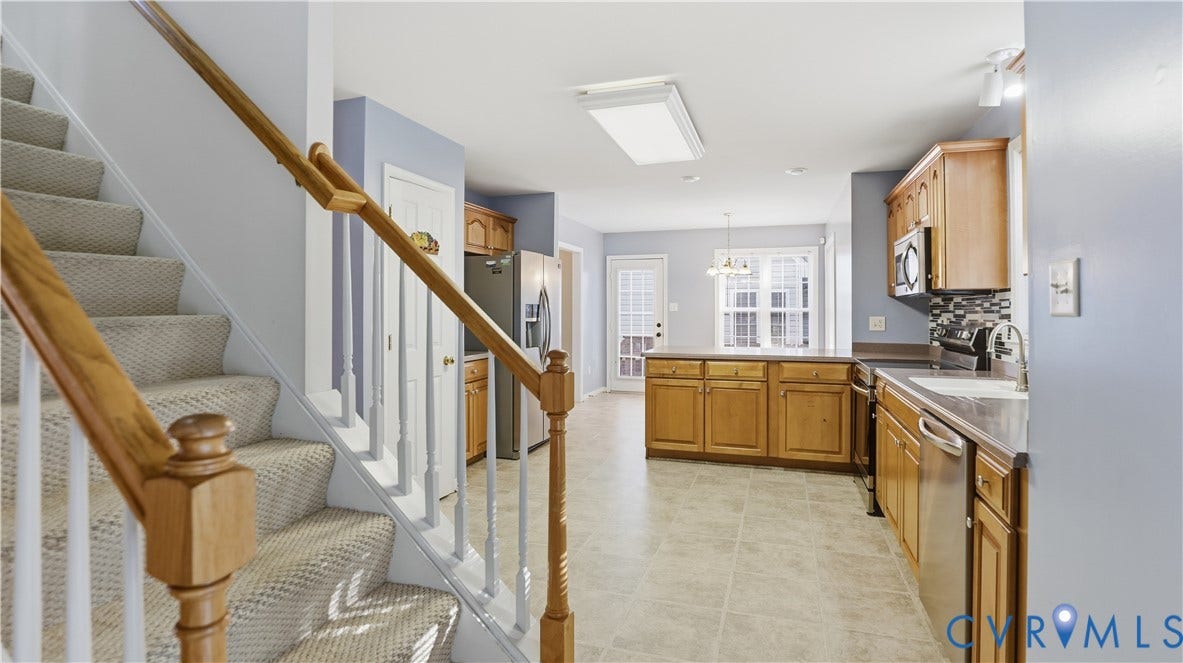 Kitchen with wood-finish cabinetry, stainless steel appliances, and a tiled backsplash