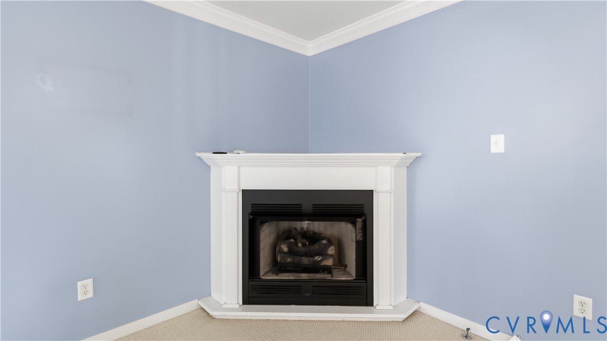 Corner fireplace with a white mantel and crown molding