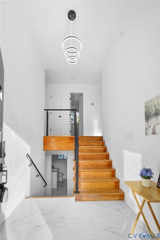 4911 Aqua Lane, Prince George, VA 23875 White marble-finish tile flooring, hardwood stairs, contemporary tiered chandelier, black metal stair railing, and white walls