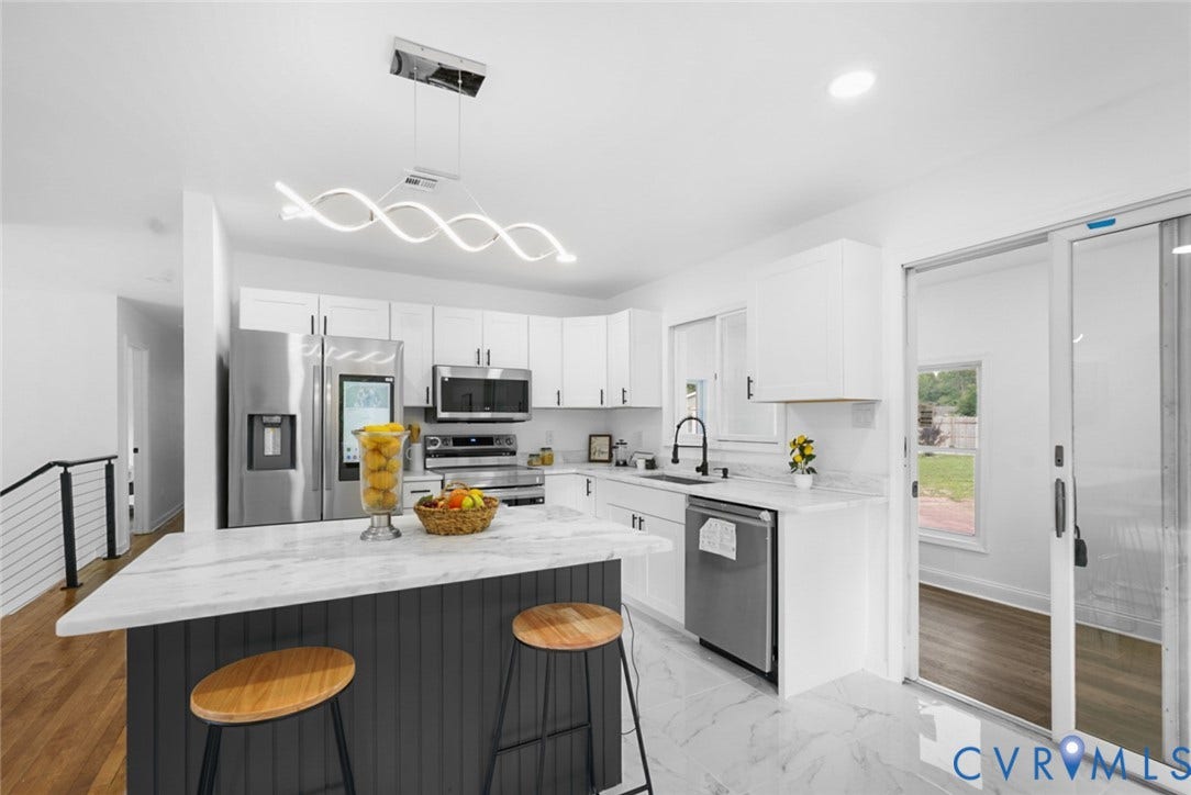 4911 Aqua Lane, Prince George, VA 23875 Kitchen featuring a center island with a stone countertop, white cabinetry with dark hardware, stainless steel appliances, and a modern linear chandelier
