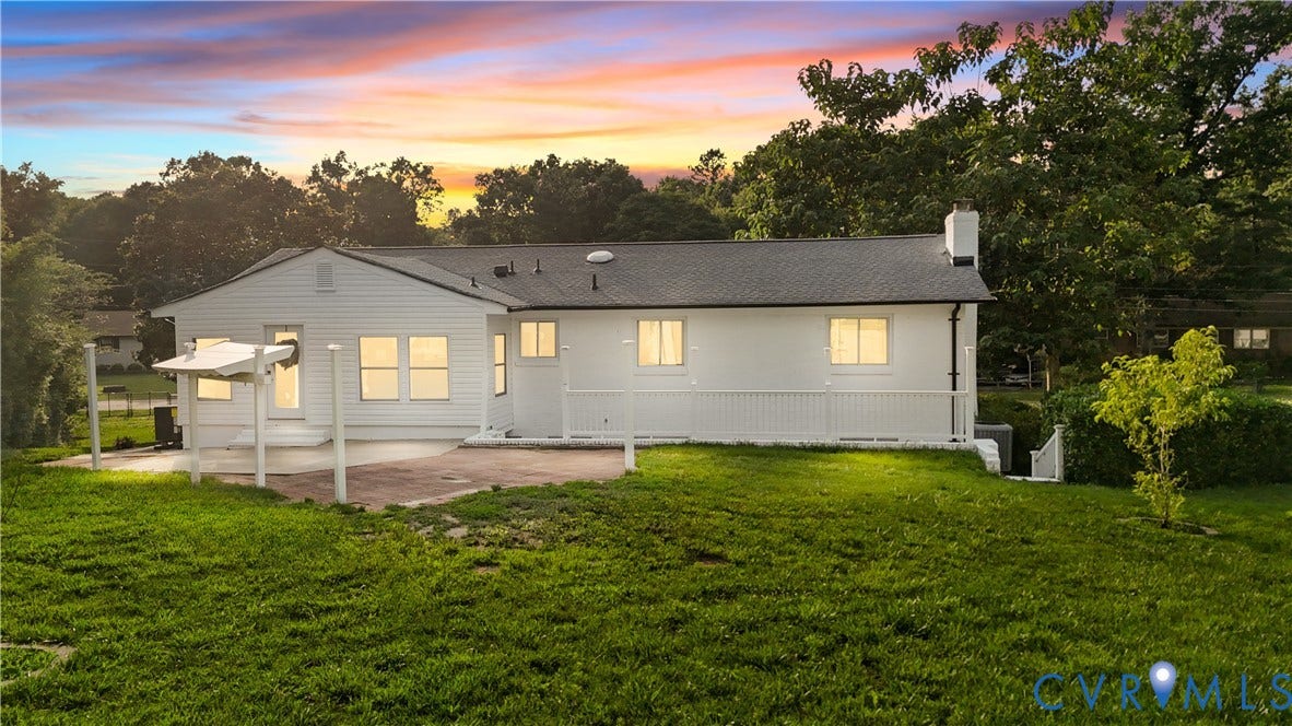 4911 Aqua Lane, Prince George, VA 23875 White siding exterior with dark shingle roofing, featuring a covered patio, a back deck with railing, and a chimney