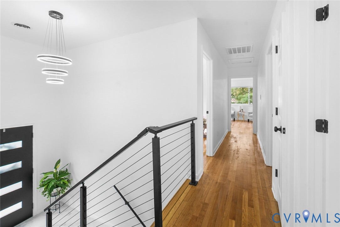 4911 Aqua Lane, Prince George, VA 23875 Modern tiered chandelier, engineered wood flooring, contemporary cable railing, crisp white walls, and black hardware