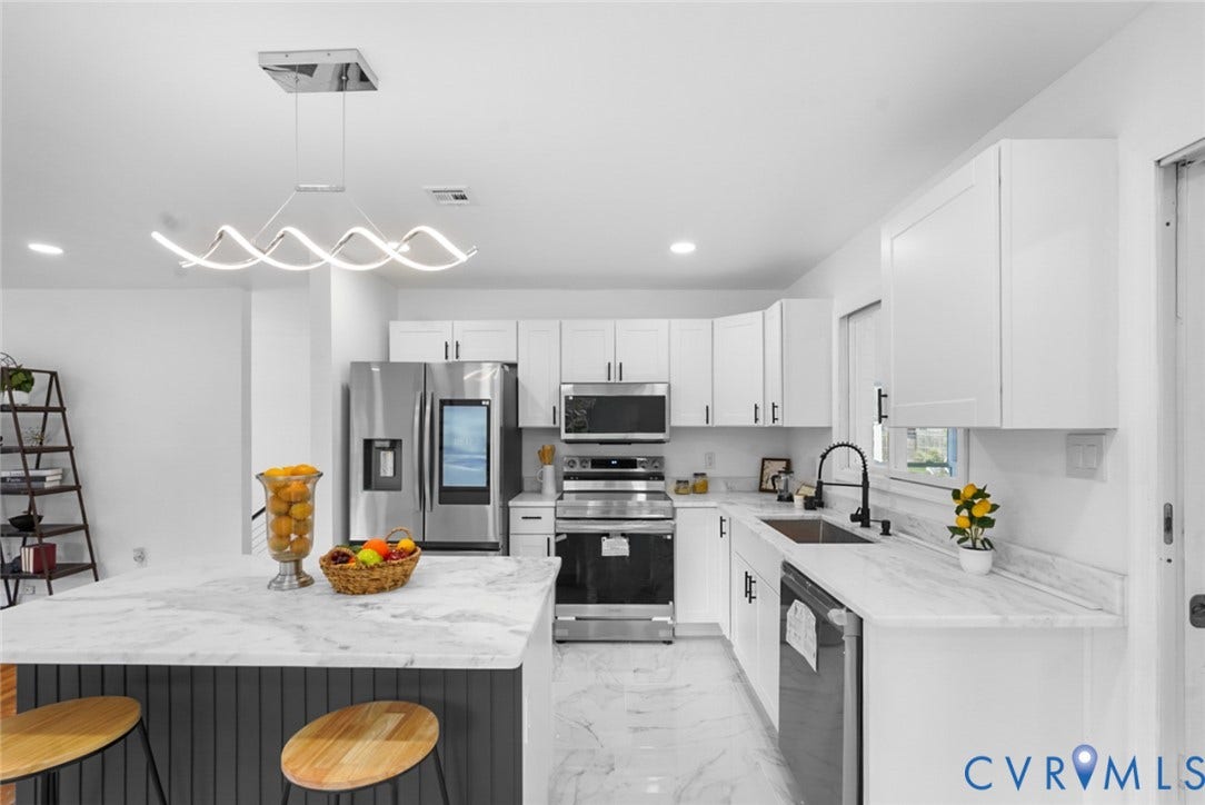 4911 Aqua Lane, Prince George, VA 23875 White cabinetry, stainless steel appliances, marbled countertops, and a contemporary linear chandelier