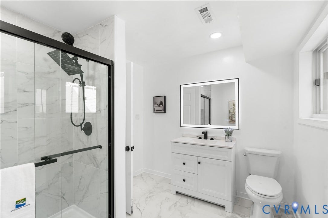 4911 Aqua Lane, Prince George, VA 23875 White vanity with black hardware, back-lit mirror, and white countertop