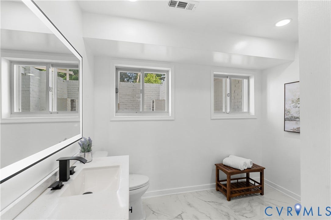 4911 Aqua Lane, Prince George, VA 23875 Bathroom featuring a floating vanity with a vessel sink, black faucet, illuminated mirror, recessed lighting, and white-patterned flooring