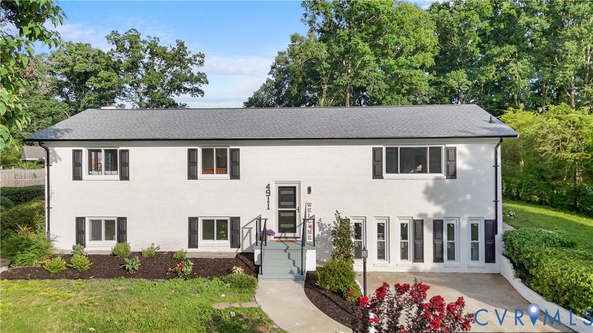 4911 Aqua Lane, Prince George, VA 23875 White brick exterior with a dark shingle roof, black shutters, and a well-maintained entry garden