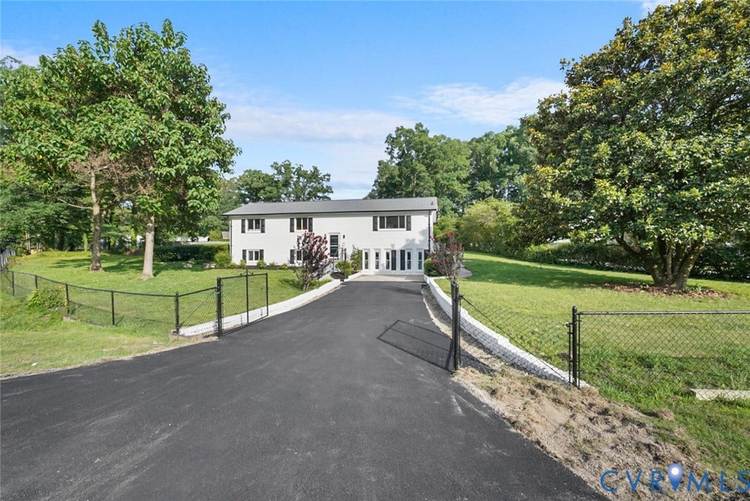4911 Aqua Lane, Prince George, VA 23875 White exterior residence with dark shutters, a paved driveway, and mature landscaping