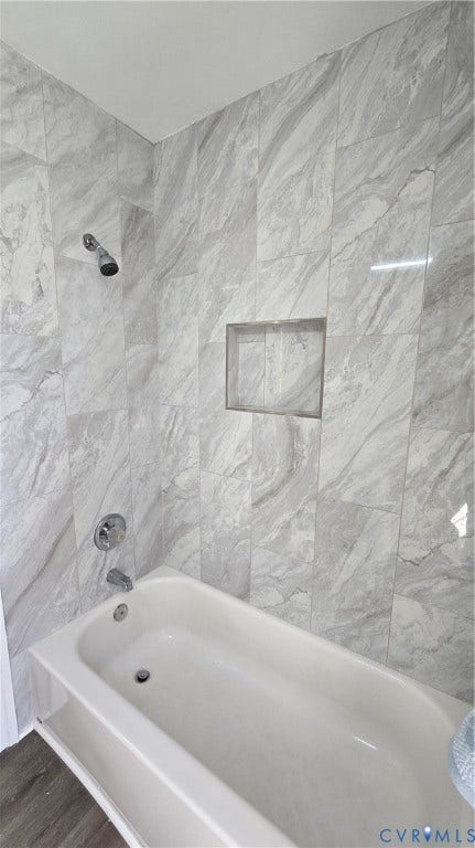 Full tile surround with an integrated shower niche, chrome showerhead, and bathtub faucet