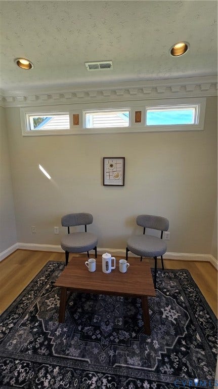 Recessed ceiling lighting, crown molding, transom windows, wood-finish flooring, and light-toned wall paint
