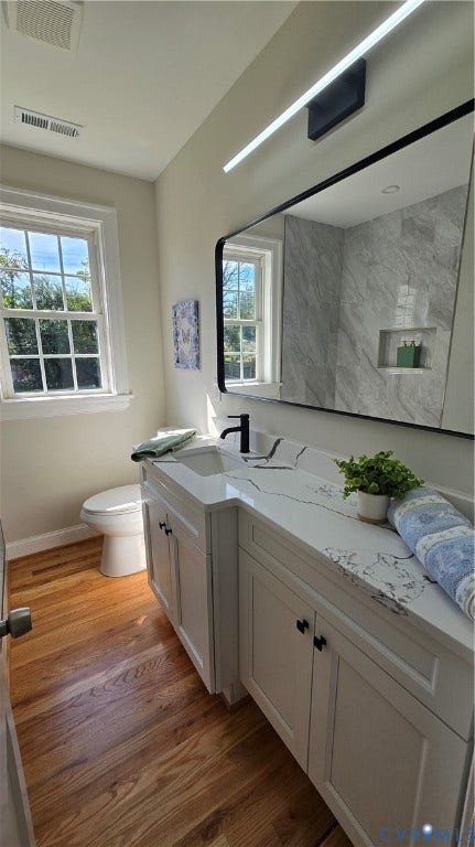 White vanity with black hardware, integrated sink, and a white countertop with grey veining