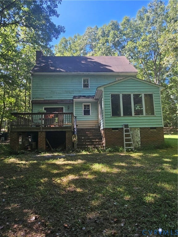Exterior siding, multi-level decking, brick foundation, wood-frame windows, and a sunroom addition