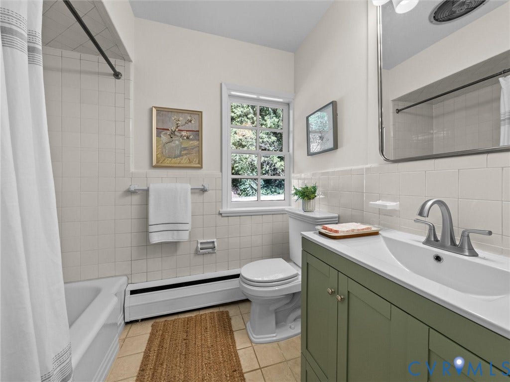 6208 Tapoan Place, Three Chopt, Richmond, VA 23226 White tiled bathroom featuring a window, white bathtub, green vanity with integrated sink, and an integrated mirror with overhead lighting