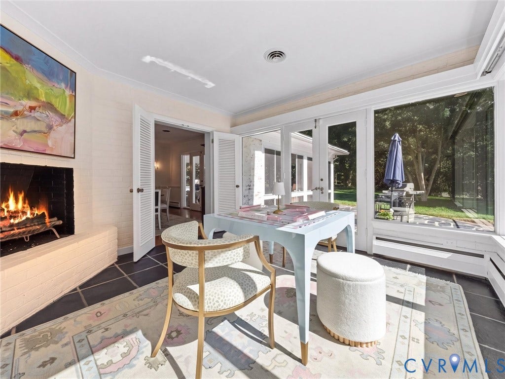 6208 Tapoan Place, Three Chopt, Richmond, VA 23226 White brick fireplace with a black firebox, black slate tile flooring, white double louvered doors, and extensive window walls