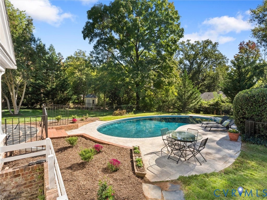 6208 Tapoan Place, Three Chopt, Richmond, VA 23226 Oval-shaped swimming pool with a stone paver surround, extensive landscaping, and a fenced perimeter
