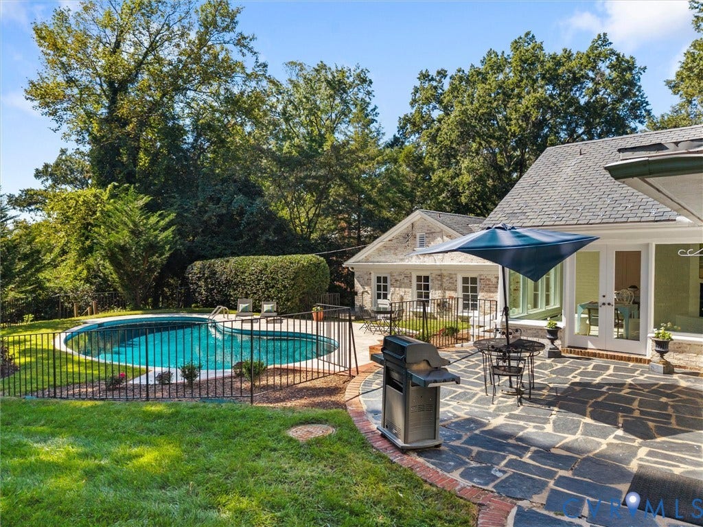 6208 Tapoan Place, Three Chopt, Richmond, VA 23226 Expansive backyard oasis featuring an in-ground swimming pool with black metal safety fencing, mature landscaping with established trees, and a stone patio