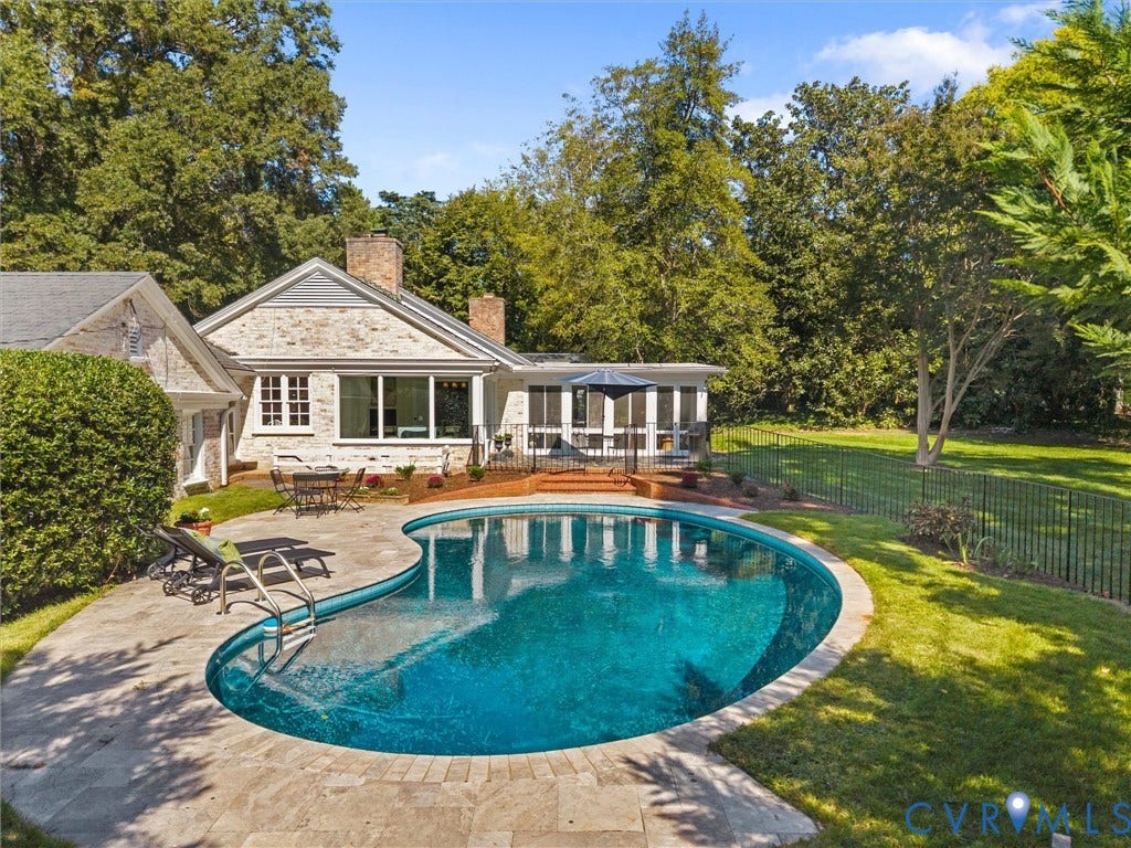 6208 Tapoan Place, Three Chopt, Richmond, VA 23226 Freeform swimming pool with stone coping, surrounded by a stone patio and mature landscaping
