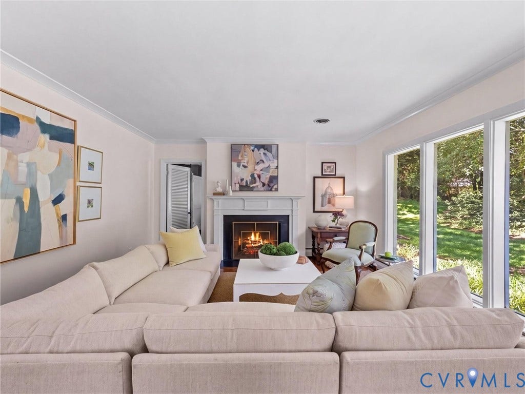 6208 Tapoan Place, Three Chopt, Richmond, VA 23226 Fireplace with a white mantel, crown molding, wood-finish flooring, and expansive windows overlooking outdoor greenery