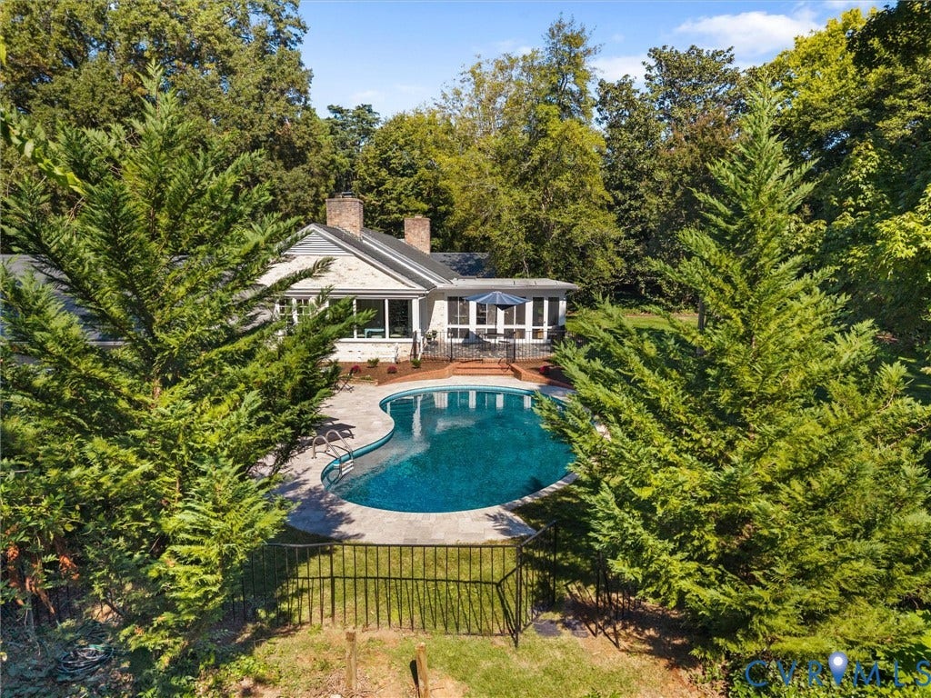 6208 Tapoan Place, Three Chopt, Richmond, VA 23226 Resort-style backyard featuring a freeform swimming pool, extensive pool decking, and surrounding mature trees
