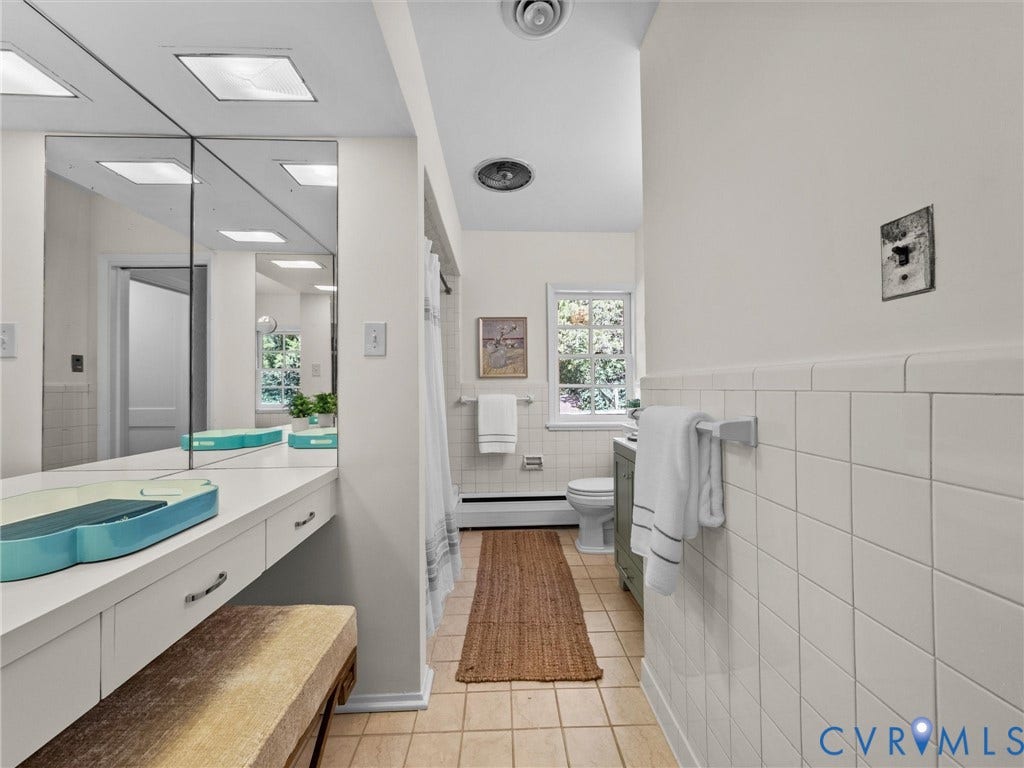 6208 Tapoan Place, Three Chopt, Richmond, VA 23226 Spa-inspired primary bathroom featuring dual vanities with turquoise countertops, an expansive mirror, subway tile wainscoting, wood-finish flooring, and abundant natural light from multiple windows