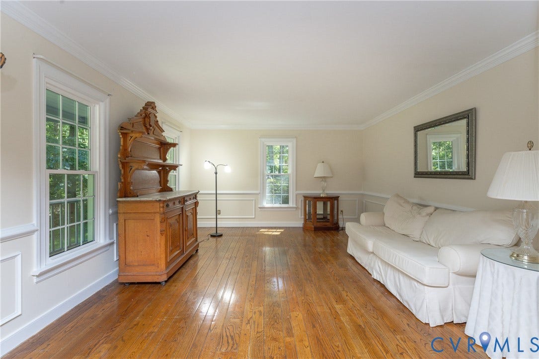 Hardwood flooring, multiple windows, crown molding, chair rail molding, and a spacious layout