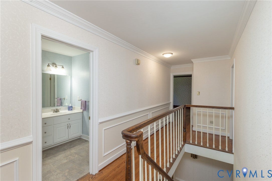 Hardwood flooring with a turned newel post and white balusters