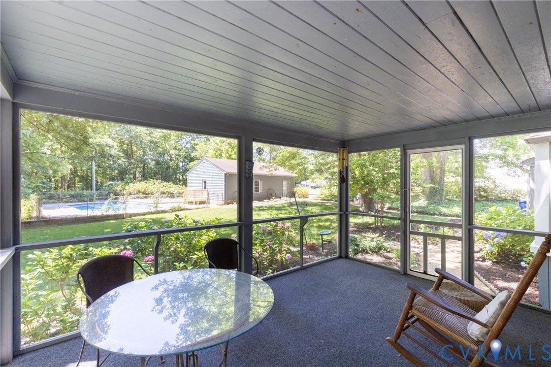 Screened porch featuring a paneled ceiling, dark gray flooring, and a screened door