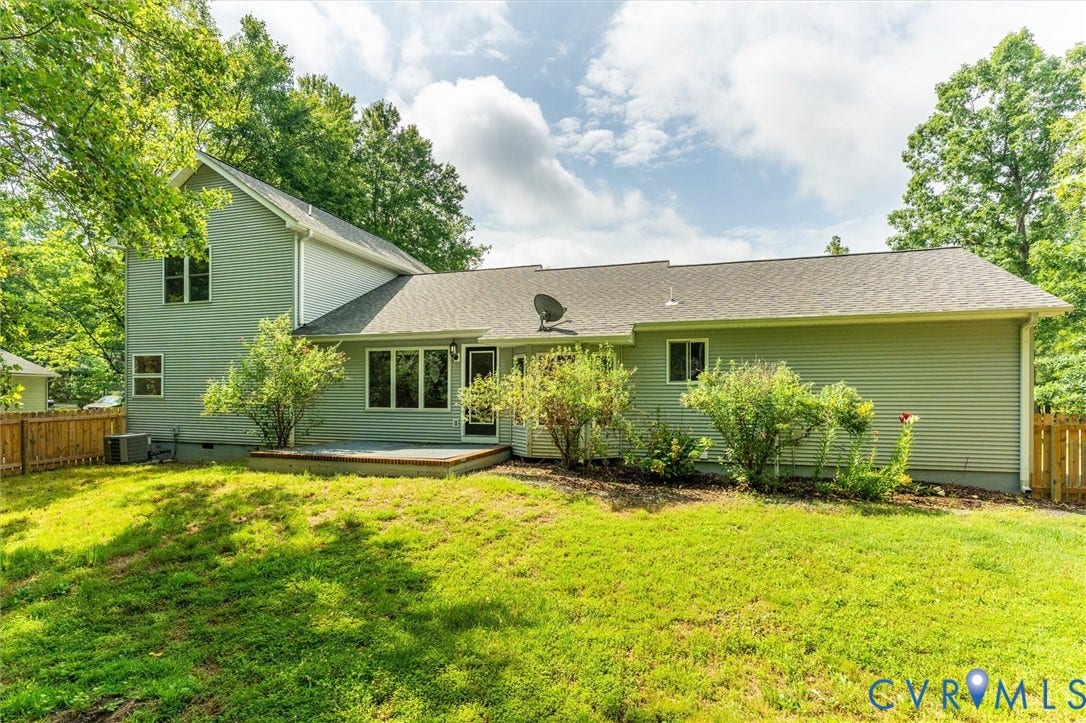 Expansive lawn with mature trees and a wood privacy fence