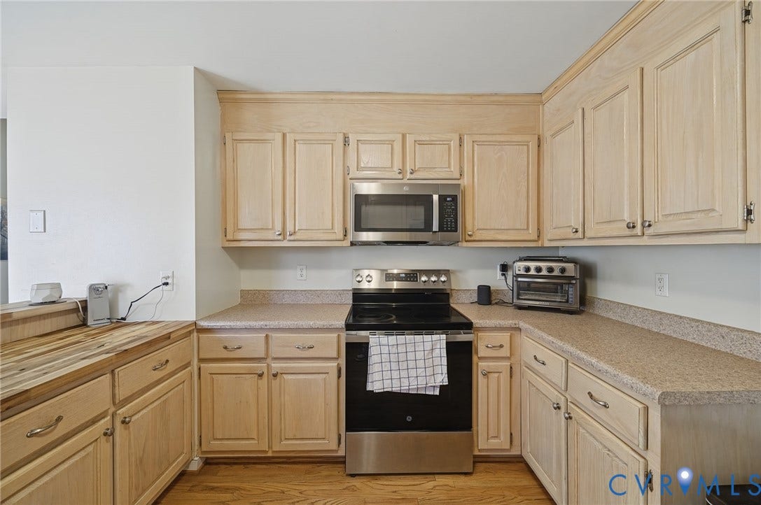 20550 Horseshoe Road, Prince George, VA 23830 Wood-finish cabinetry with silver hardware, laminate countertops, stainless steel appliances, and wood-finish flooring