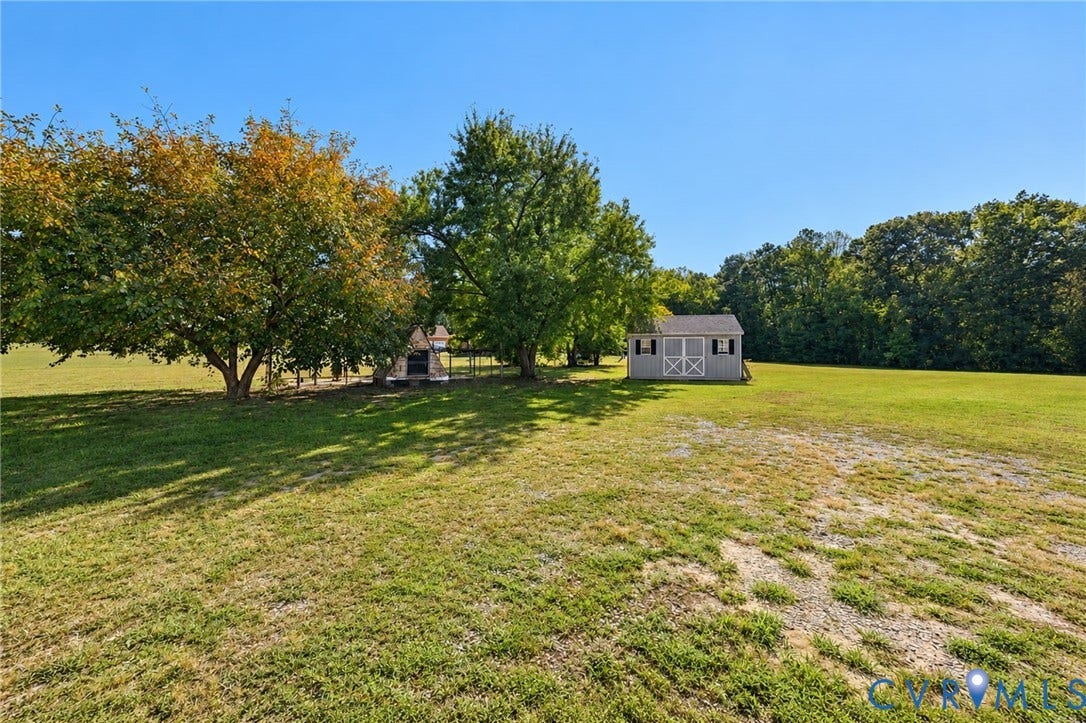 20550 Horseshoe Road, Prince George, VA 23830 Expansive grassy area featuring mature trees and a detached shed with a gable roof