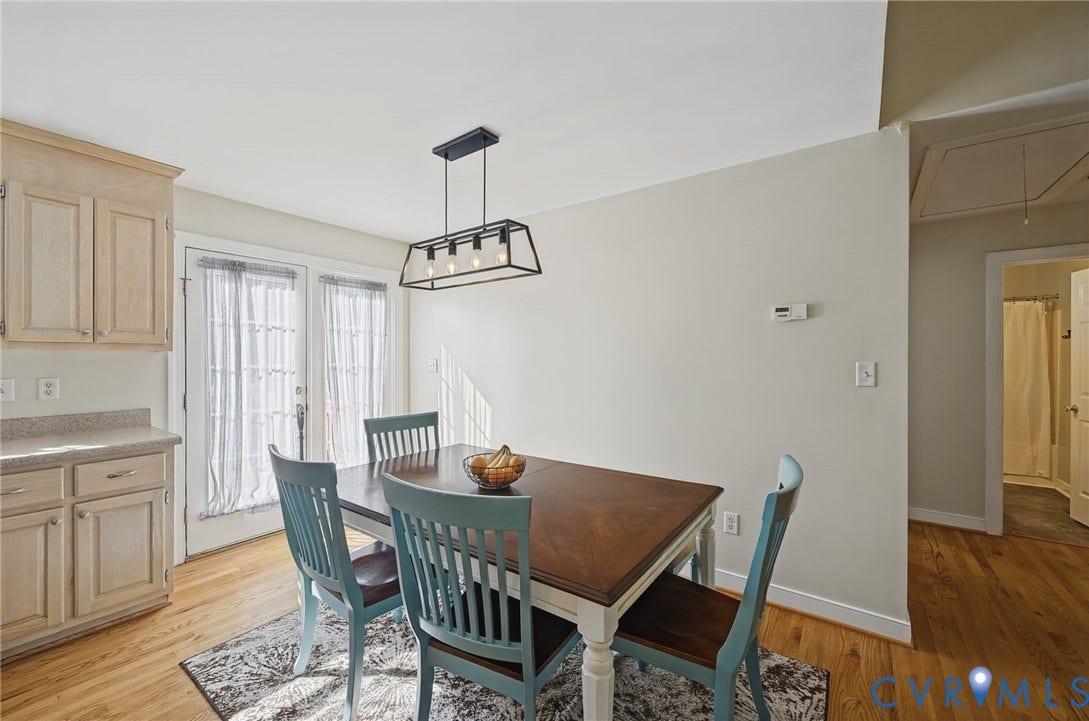 20550 Horseshoe Road, Prince George, VA 23830 Hardwood flooring throughout, light wood-finish cabinetry, light-toned countertop, and a modern linear chandelier