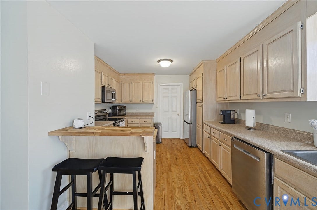 20550 Horseshoe Road, Prince George, VA 23830 Wood-finish flooring with light-toned cabinetry, stainless steel appliances, and an integrated breakfast bar