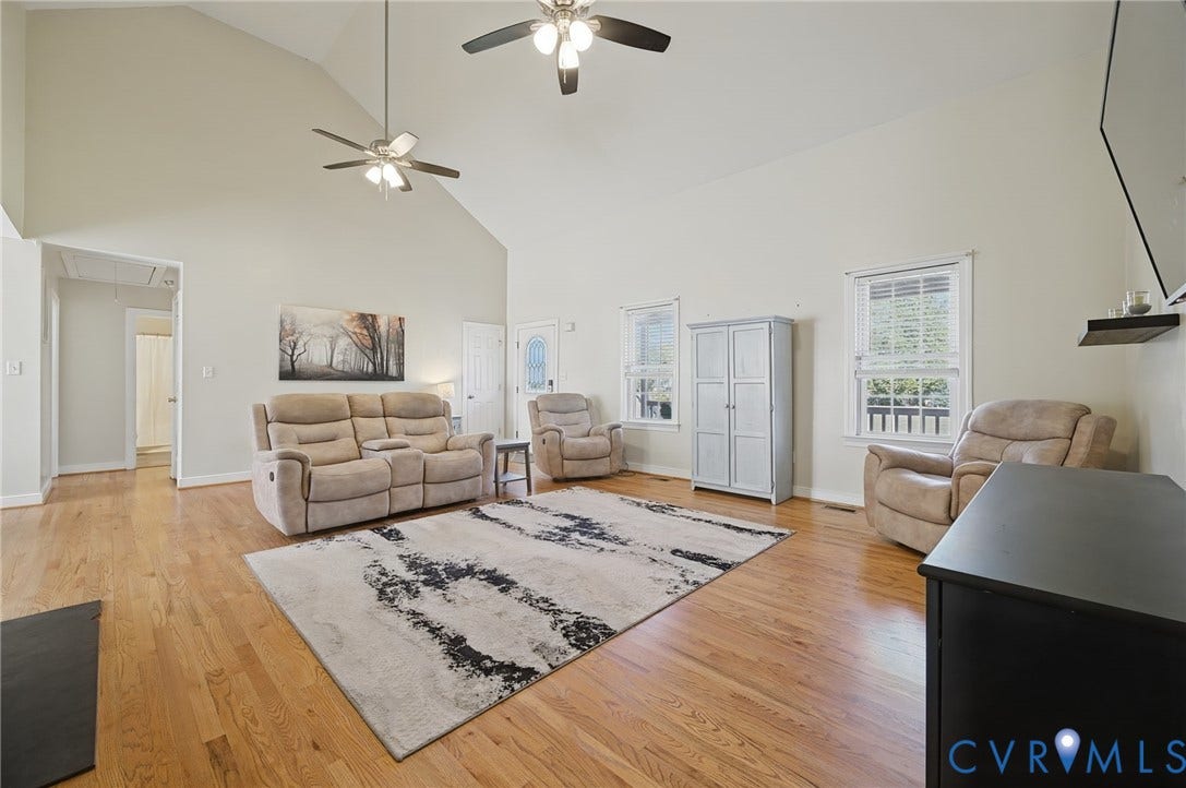 20550 Horseshoe Road, Prince George, VA 23830 Vaulted ceiling with dual ceiling fans, wood-finish flooring, multiple windows, and a white paneled door