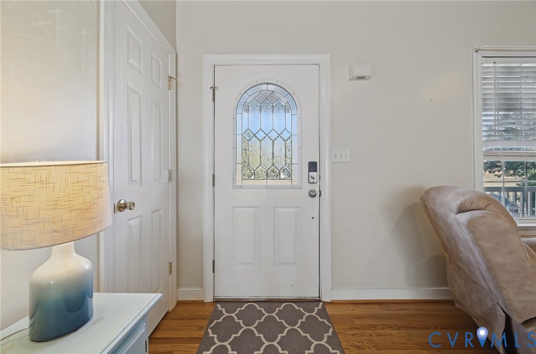 20550 Horseshoe Road, Prince George, VA 23830 White paneled interior door, wood-finish flooring, white entry door with decorative glass inlay, and a window with blinds