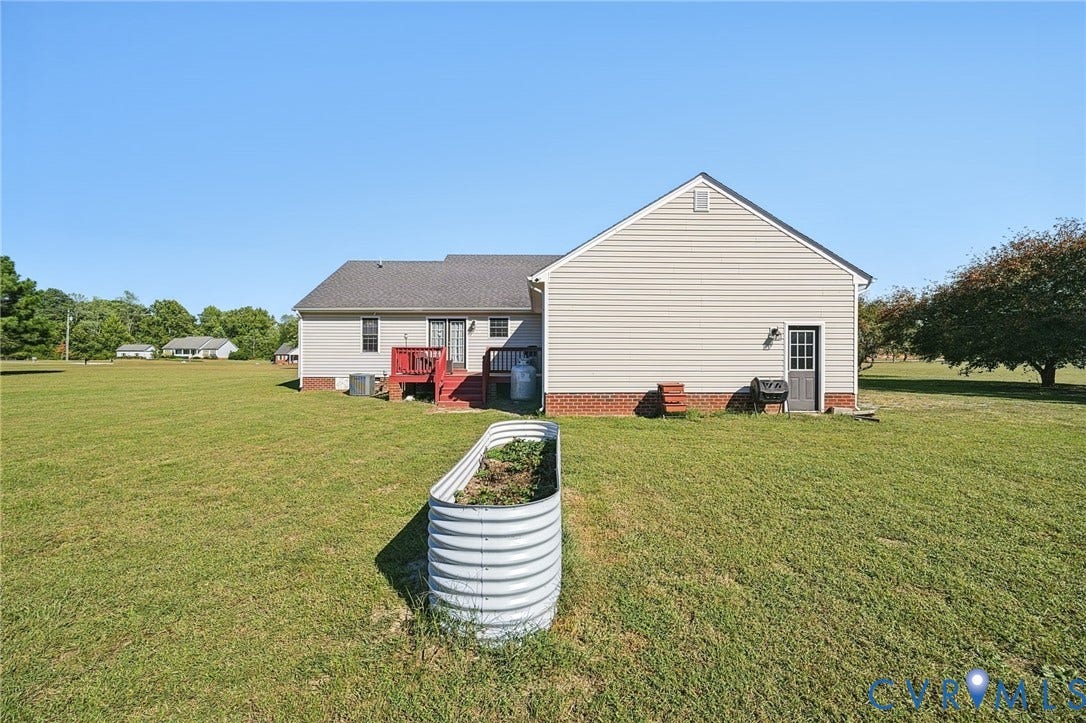 20550 Horseshoe Road, Prince George, VA 23830 Expansive rear yard featuring green lawn, a raised garden bed, and mature trees