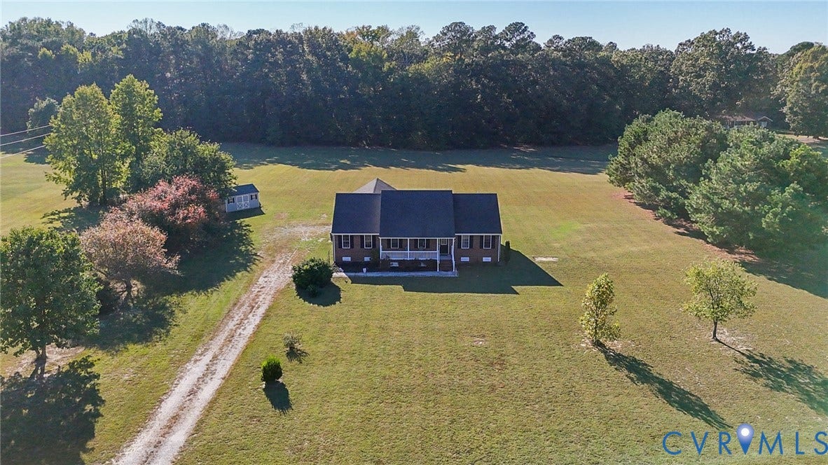 20550 Horseshoe Road, Prince George, VA 23830 Expansive lot featuring a single-story residence, gravel driveway, mature trees, and an accessory structure