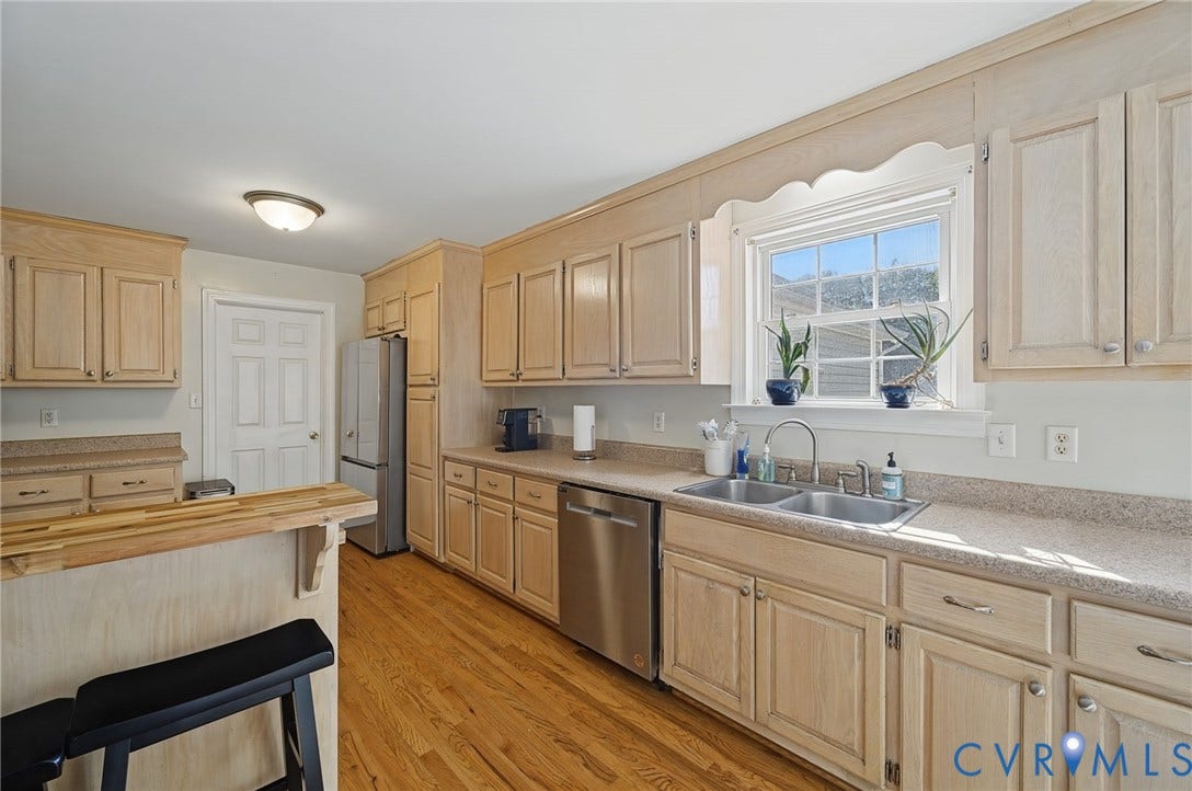 20550 Horseshoe Road, Prince George, VA 23830 Kitchen featuring wood cabinetry, stainless steel appliances, dual basin sink, and a breakfast bar