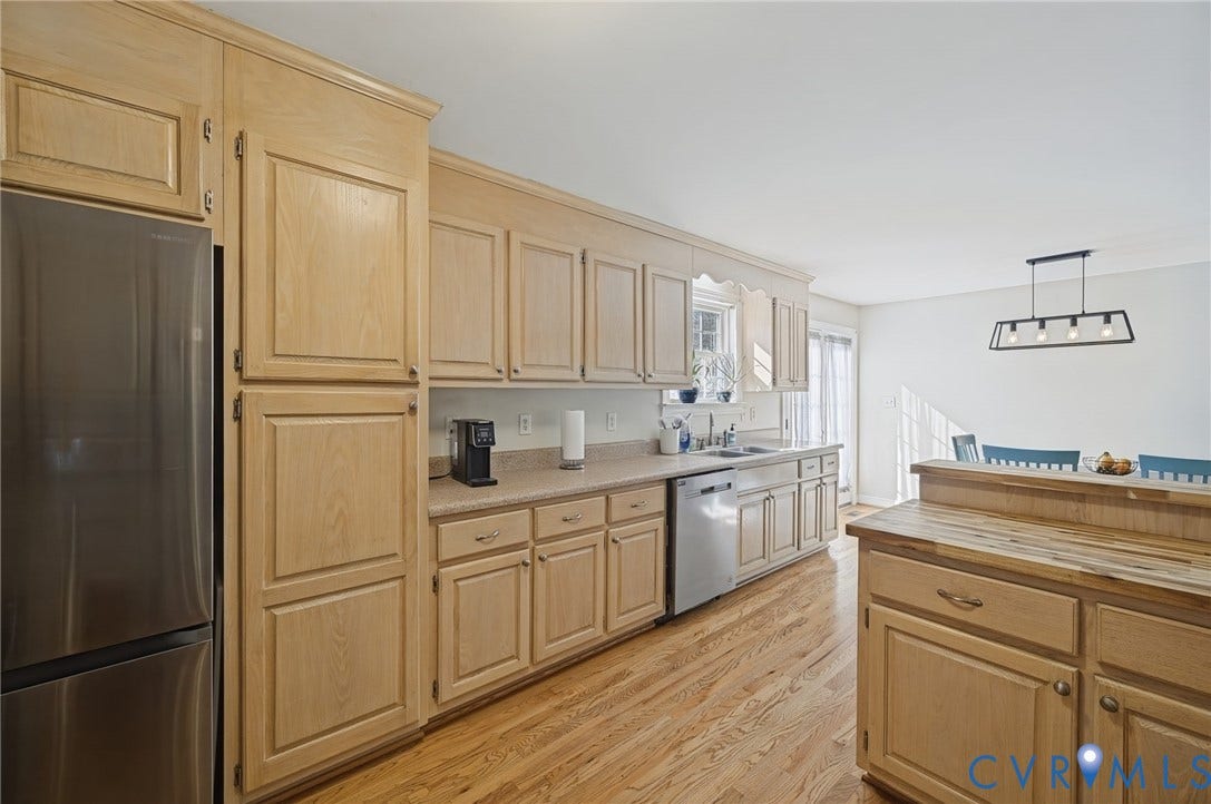20550 Horseshoe Road, Prince George, VA 23830 Kitchen featuring extensive light wood cabinetry, stainless steel appliances, light-toned countertops, wood-finish flooring, and a contemporary linear chandelier